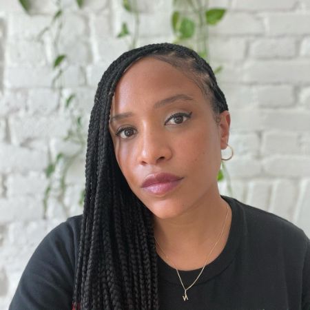 She is looking beautiful in black t-shirt with tied hair.